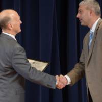 Dean Potteiger shaking hands with person receiving an award